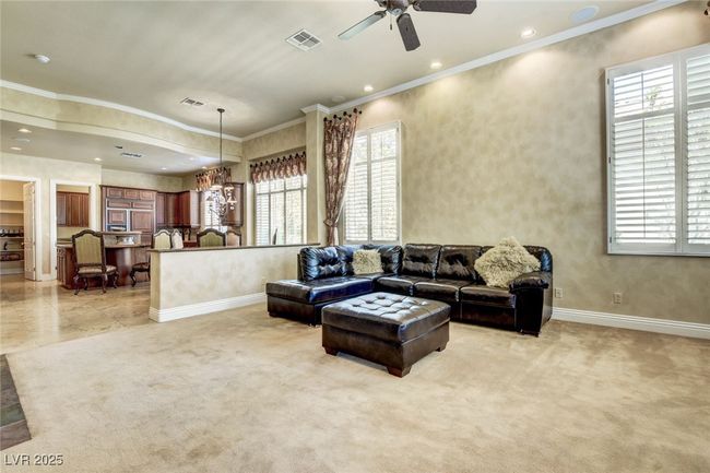 Living area featuring visible vents, a healthy amount of sunlight, a ceiling fan, and crown molding | Image 14