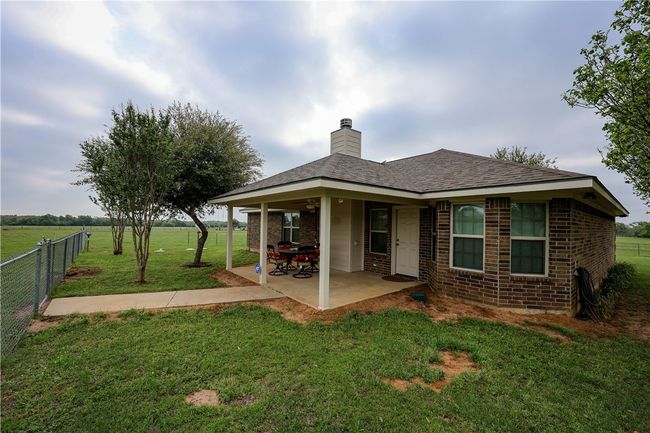 Rear view of property with brick siding, fence, a yard, and a patio area | Image 12