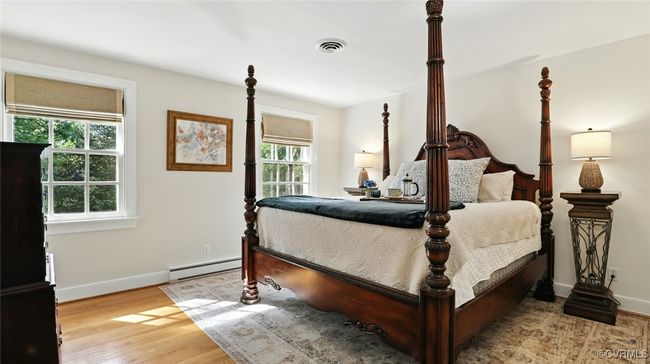 Bedroom featuring light wood-type flooring and a baseboard heating unit | Image 27