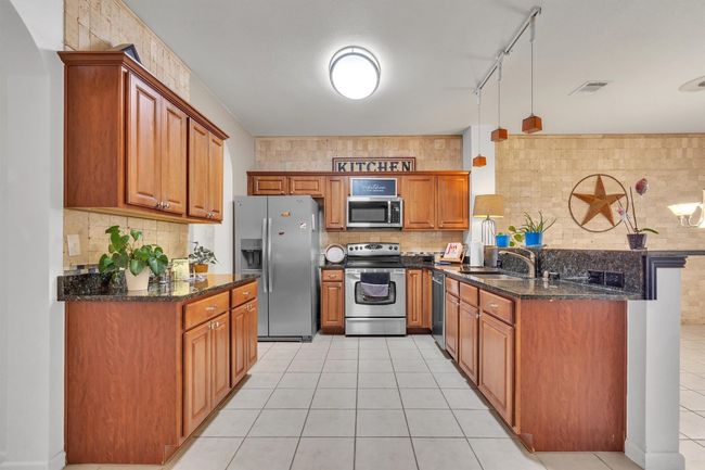 View of the kitchen from the living room, brand new microwave, refrigerator conveys | Image 6