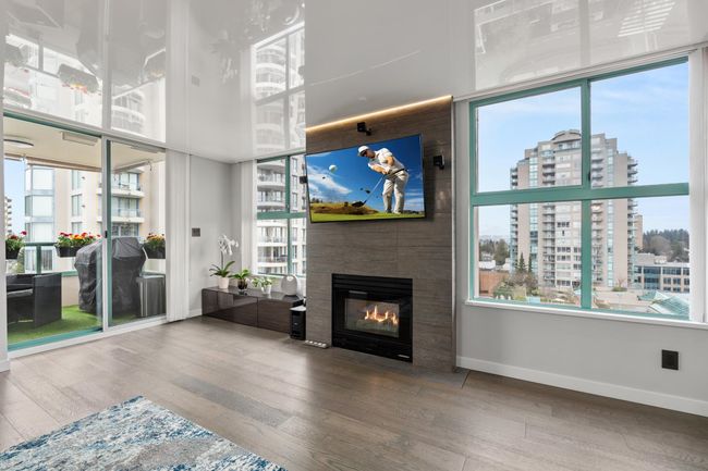 Living area featuring a glass covered fireplace, baseboards, and wood finished floors | Image 11
