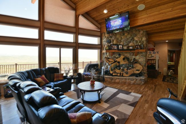 Living area featuring a fireplace, a healthy amount of sunlight, high vaulted ceiling, and wooden ceiling | Image 71
