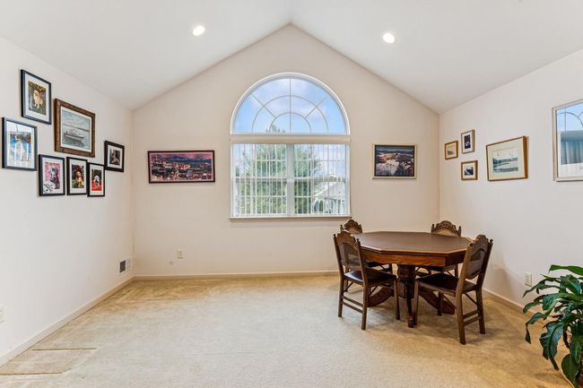 Dining space featuring baseboards, carpet floors, lofted ceiling, and a healthy amount of sunlight | Image 23