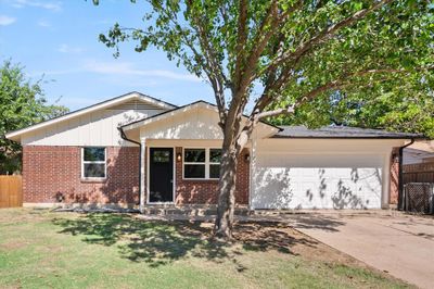 Ranch-style house featuring a garage and a front lawn. Freshly Painted. Small Front Porch | Image 1