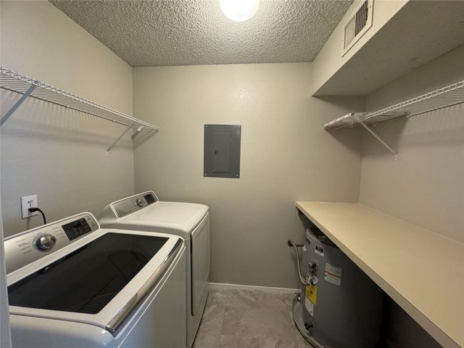Washroom with electric panel, independent washer and dryer, a textured ceiling, and baseboards | Image 7