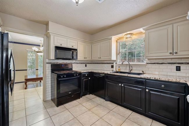 A chef's delight, this kitchen has been updated and boasts granite counters and cabinets galore. | Image 11