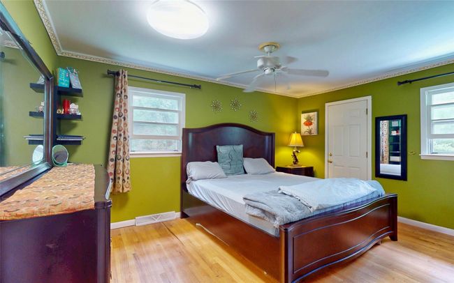 Bedroom featuring light wood-style floors, baseboards, ceiling fan, and crown molding | Image 25