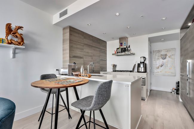 Kitchen with a sink, a kitchen bar, a peninsula, modern cabinets, and open shelves | Image 7