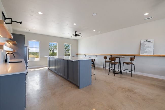 Kitchen featuring a breakfast bar, concrete floors, baseboards, open shelves, and recessed lighting | Image 26