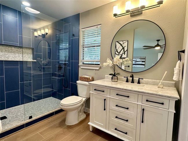 Bathroom featuring a ceiling fan, vanity, a stall shower, and hard tile floors | Image 13