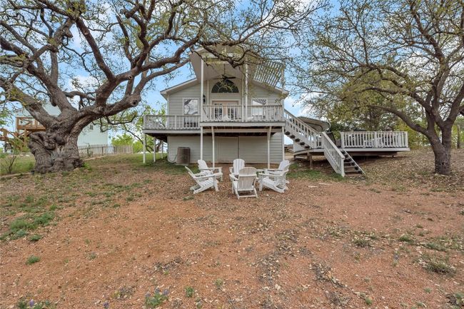 Rear view of property with a fire pit, a wooden deck, and stairway | Image 30
