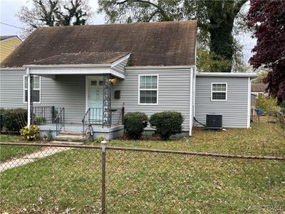 New england style home with cooling unit and a front yard | Image 1