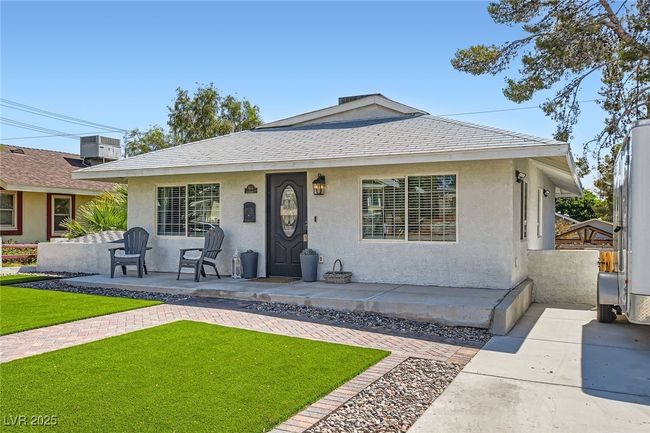 Bungalow-style house featuring stucco siding, a front yard, and a shingled roof | Image 4