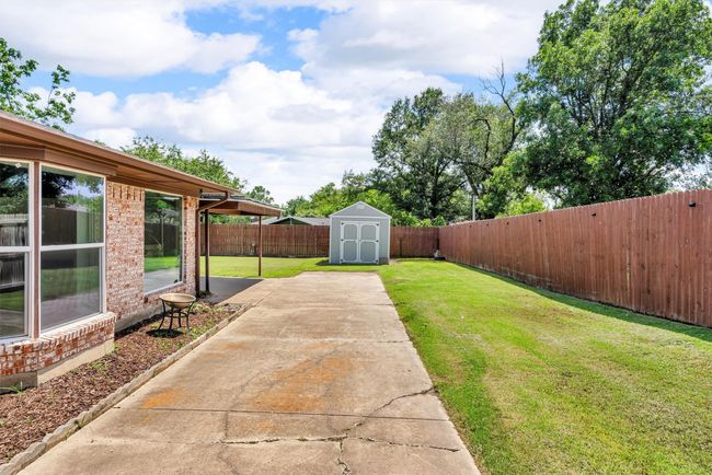 Side yard, driveway that leads to the car port and two car garage. | Image 29