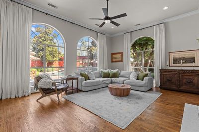 Beautiful arched windows gracing the family room with natural light. The wood flooring brings warmth and the ornamental molding drama. The gorgeous view of the pool is not to be missed! | Image 1