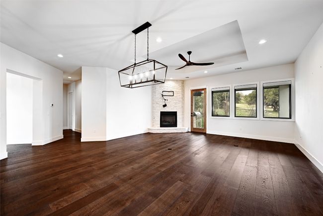 Unfurnished living room with recessed lighting, baseboards, ceiling fan, and dark wood-style flooring | Image 6