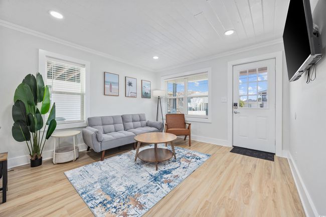 Living area featuring crown molding, baseboards, light wood-style floors, and recessed lighting | Image 16