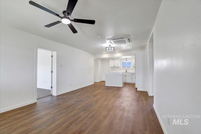 Unfurnished living room with dark wood-style flooring and ceiling fan | Image 13