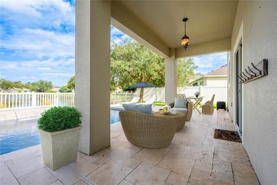 The sparkling pool is surrounded by a TRAVERTINE DECK and the COVERED PATIO gives you an ideal place to relax poolside and take advantage of the WATER VIEWS! Virtually Staged. | Image 3