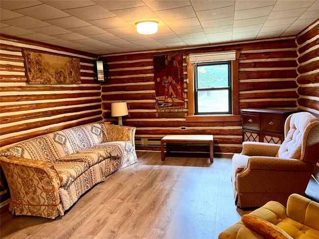 Living room featuring rustic walls and wood finished floors | Image 8