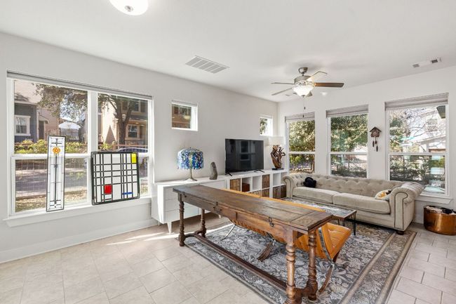Tiled living room with plenty of natural light, ceiling fan, and visible vents | Image 4