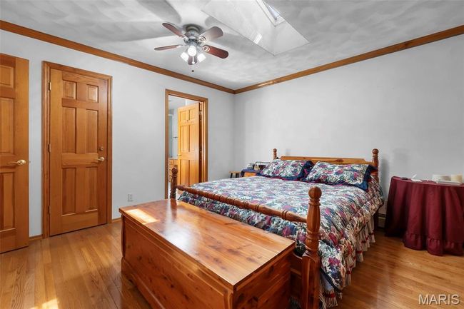 Bedroom with wood-type flooring, ornamental molding, and ceiling fan | Image 70