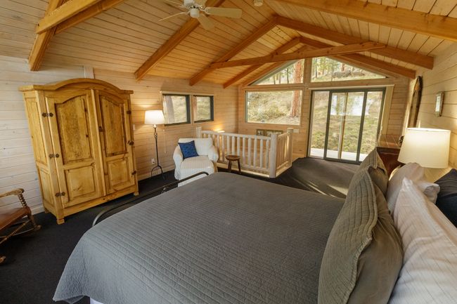 Bedroom with wooden walls, lofted ceiling with beams, and wood ceiling | Image 40