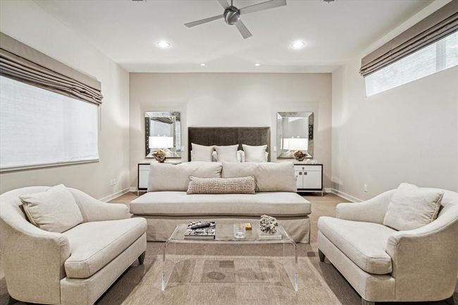 Another view of the Primary Bedroom showing the oversized window with shades that overlooks the backyard pool area and the raised window allowing natural light to enter the retreat without sacrificing privacy from neighboring residences. | Image 22