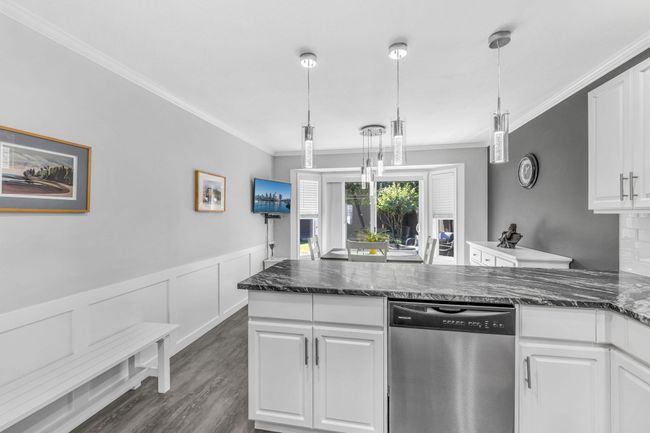 Kitchen with white cabinets, dishwasher, dark wood-style flooring, and crown molding | Image 13