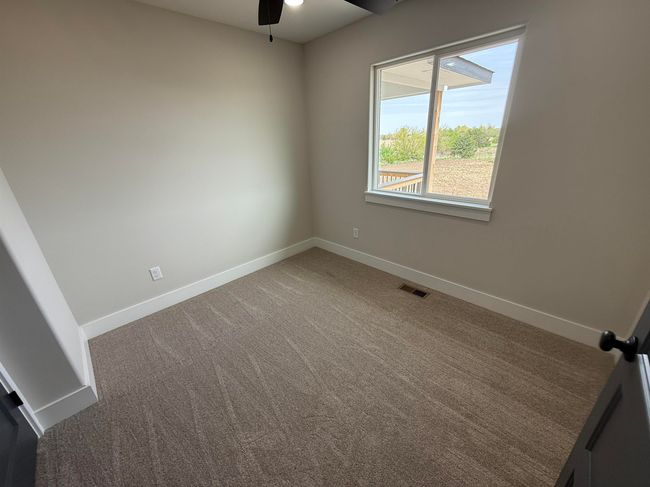 Carpeted empty room with ceiling fan and baseboards | Image 11
