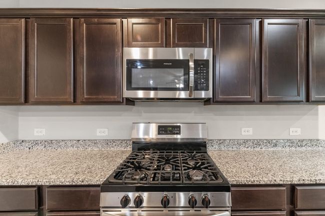 Closer view of those rich, dark and storage providing cabinets. Also, please note the 5-burner gas stove. | Image 18