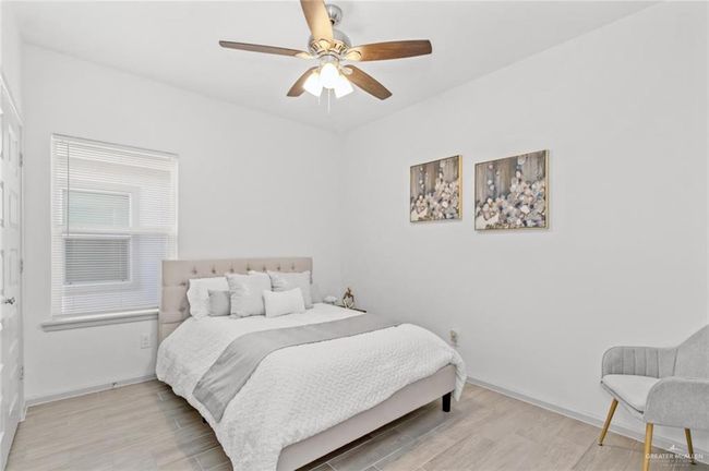 Bedroom with wood finished floors and ceiling fan | Image 9