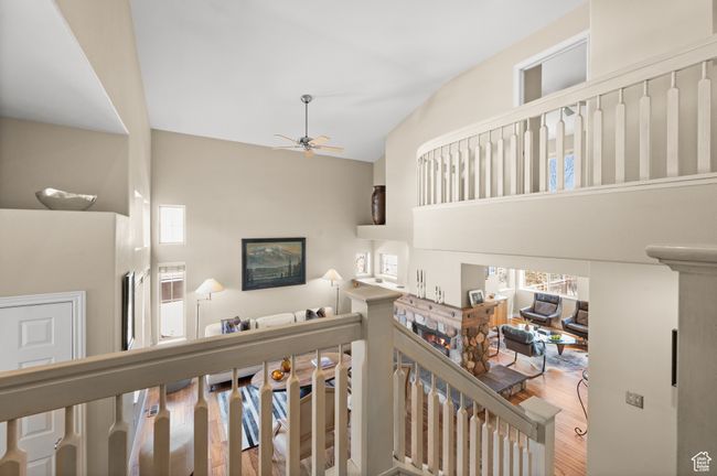 Staircase with wood finished floors, high vaulted ceiling, and ceiling fan | Image 6