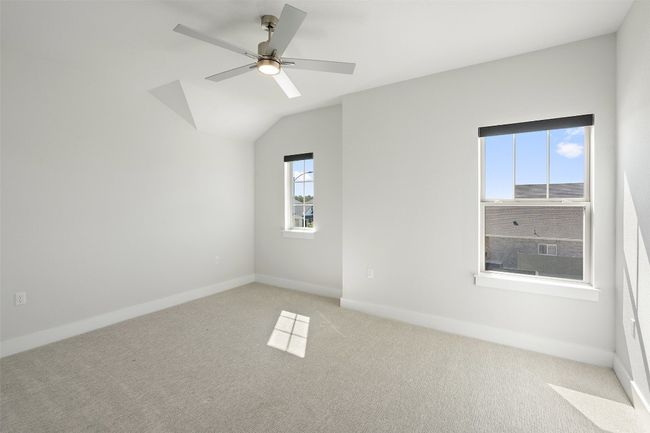 Empty room with light carpet, ceiling fan, and vaulted ceiling | Image 29
