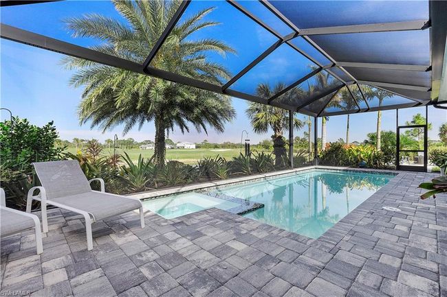 View of swimming pool with a patio area, a pool with connected hot tub, and a lanai | Image 22