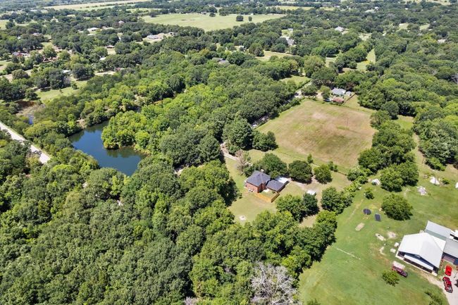 Drone / aerial view of a nearby body of water and a heavily wooded area | Image 30