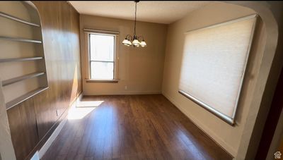 Unfurnished room featuring a textured ceiling, dark hardwood / wood-style flooring, and a chandelier | Image 3