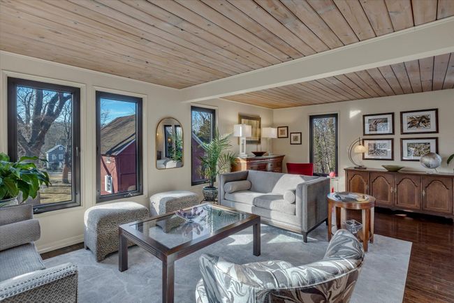 Living room with beamed ceiling, wooden ceiling, and light hardwood / wood-style flooring | Image 7