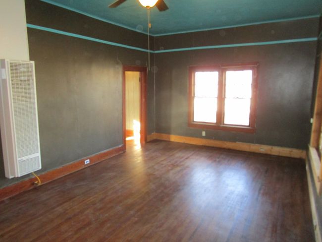 Spare room with a heating unit, baseboards, and wood finished floors | Image 10