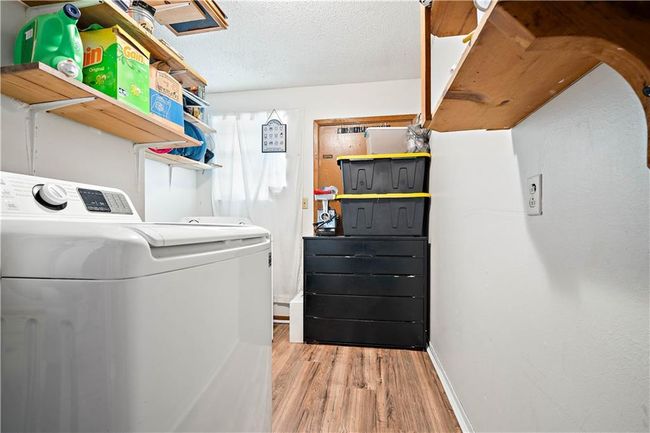 Laundry room with laundry area, baseboards, a textured ceiling, light wood finished floors, and independent washer and dryer | Image 18