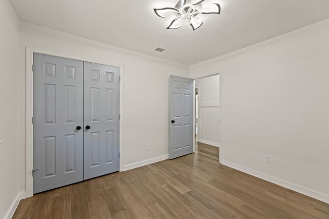 Unfurnished bedroom with baseboards, visible vents, a closet, and wood finished floors | Image 25