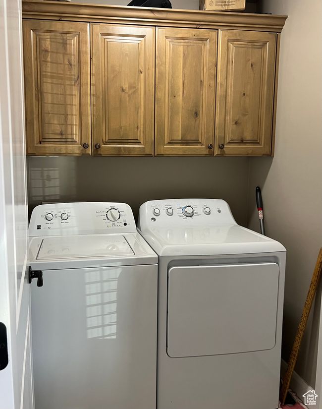 Laundry area featuring washing machine and dryer and cabinet space | Image 28