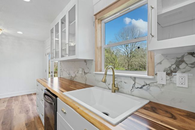 Kitchen featuring glass insert cabinets, white cabinets, dishwasher, a sink, and recessed lighting | Image 22
