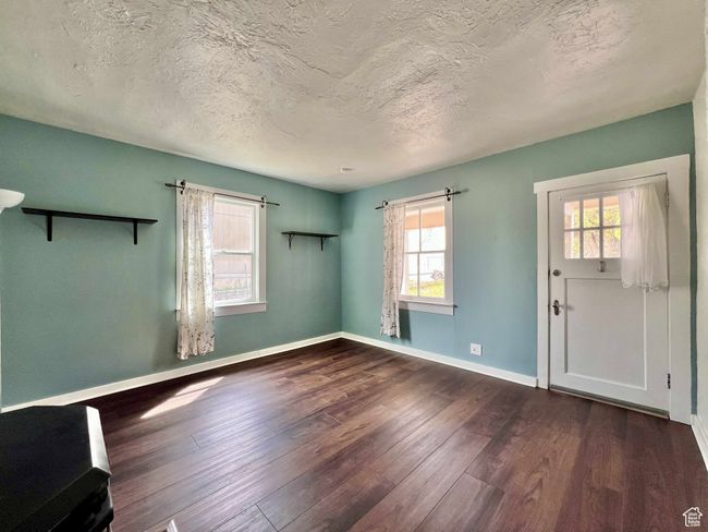 Spare room featuring baseboards, wood finished floors, a wealth of natural light, and a textured ceiling | Image 8