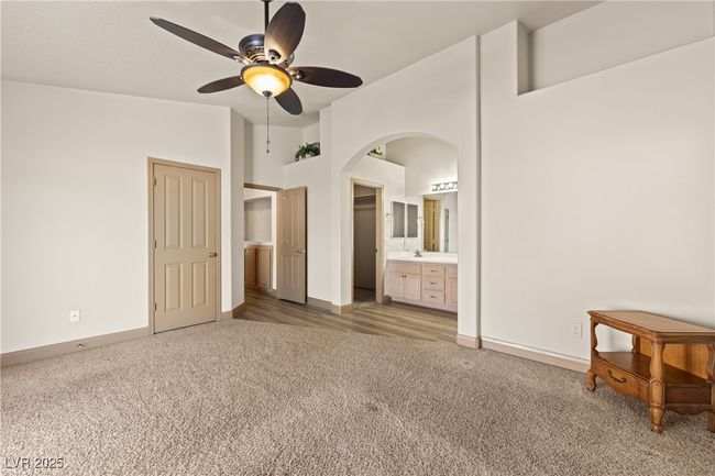 Bedroom with carpet flooring, ensuite bath, arched walkways, and a ceiling fan | Image 31