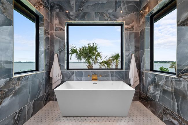 Full bathroom with a freestanding tub, a healthy amount of sunlight, and tile walls | Image 17