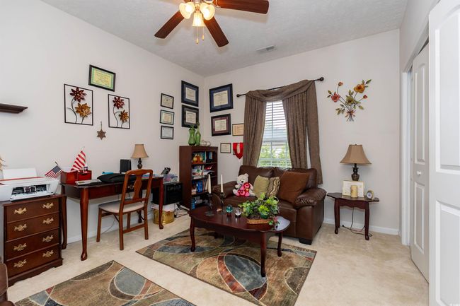 Home office featuring visible vents, a ceiling fan, and light carpet | Image 15