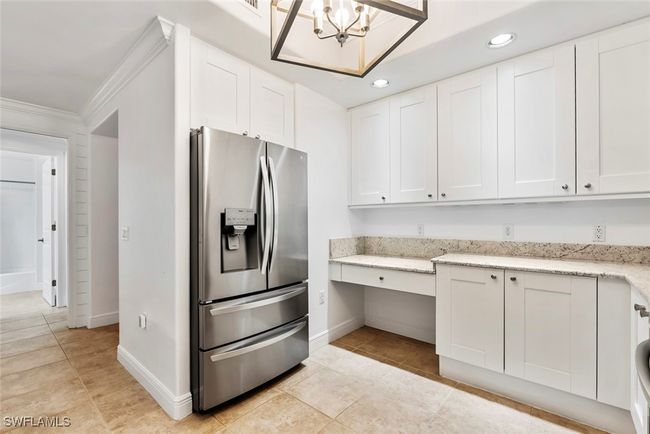 Kitchen with white cabinets and stainless steel refrigerator with ice dispenser | Image 32