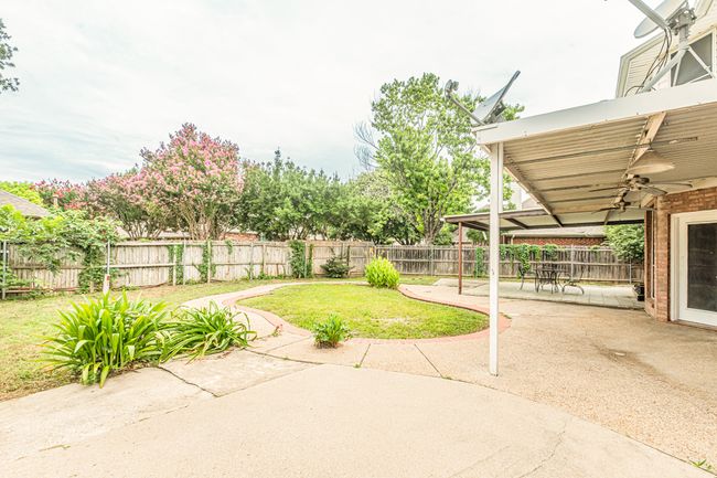 Fenced backyard featuring ceiling fan and a patio area | Image 35