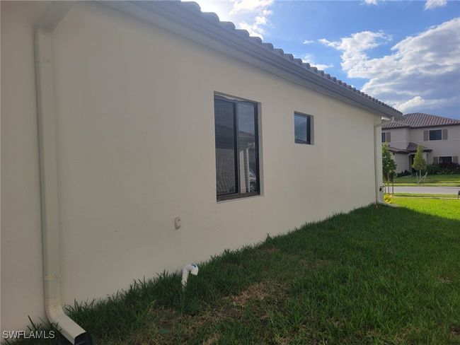 View of side of home featuring a lawn and stucco siding | Image 34